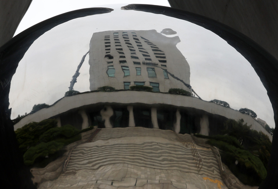 The Supreme Prosecutors’ Office building is reflected in a sculpture installed at its headquarters in Seocho District, southern Seoul, on Sept. 25, ahead of a parliamentary vote on a government reorganization bill that includes abolishing the prosecution service. The Democratic Party has vowed to pass the bill, while the People Power Party has pledged to respond with a filibuster. [YONHAP]