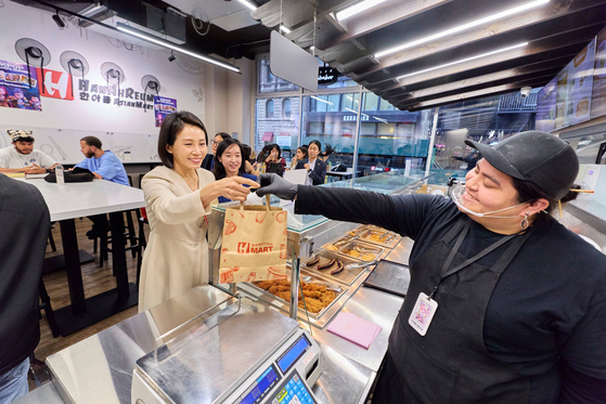 First lady Kim Hea Kyung, left, buys food at a grocery store in Koreatown in New York on Sept. 23. [JOINT PRESS CORPS]
