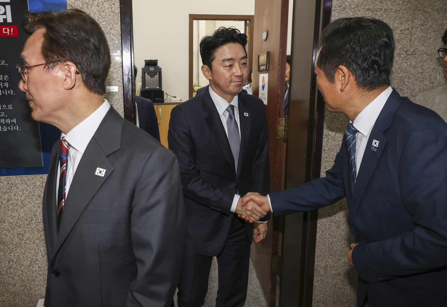 Democratic Party leader Rep. Jung Chung-rae, right, and Kang Hoon-sik, presidential chief of staff, center, shake hands after a meeting at the party leader’s office in the National Assembly on Sept. 25. Prime Minister Kim Min-seok is seen on the left. [YONHAP]
