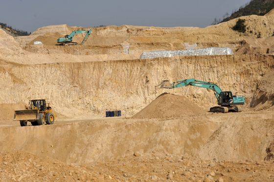 Workers use machinery to dig at a rare earth mine in Ganxian county in central China's Jiangxi province on Dec. 30, 2010. [AP/YONHAP]
