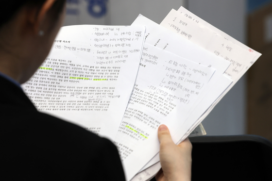 A job seeker reads documents in preparation for an on-site interview at a job fair at Dongdaemun Design Plaza (DDP) in Seoul on Aug. 20. [YONHAP]