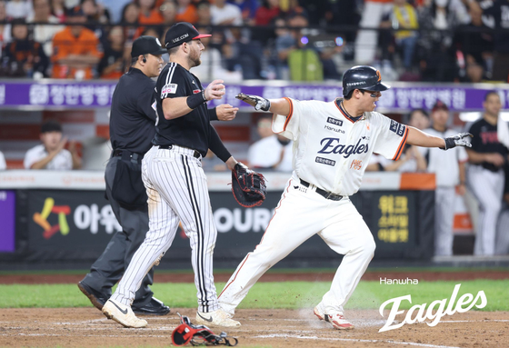 Roh Si-hwan of the Hanwha Eagles (R) makes the safe gesture after crossing the home plate during a KBO regular-season game against the LG Twins at Daejeon Hanwha Life Ballpark in Daejeon on Sept. 26, in this photo provided by the Eagles. [YONHAP]