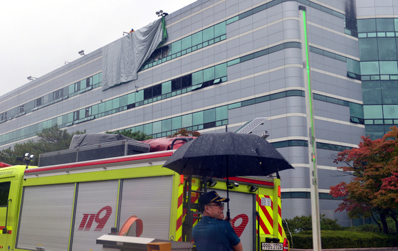 Officials cover broken windows with waterproof sheets at the National Information Resources Service in Daejeon on Sept. 28 after a fire triggers an emergency. [KIM SUNG-TAE]