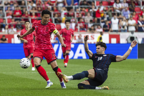 Korea's Son Heung-min, left, is tackled by Maximilian Arfsten, right during a friendly against the United States at Sports Illustrated Stadium in Harrison, New Jersey on Sept. 6. [AP/YONHAP] 