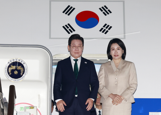President Lee Jae Myung, left, and first lady Kim Hea Kyung arrive at Seoul Air Base in Seongnam, Gyeonggi, on Sept. 26, concluding a five-day trip to New York to attend the UN General Assembly. [JOINT PRESS CORPS]