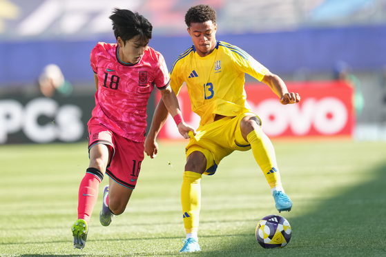 Korea's Choi Byeong-wook, left, vies for the ball with Daniel Vernattus during a 2025 FIFA U-20 World Cup match against Ukraine at Elias Figueroa Brander Stadium in Valparaiso, Chile on Sept. 27. [AP/YONHAP]