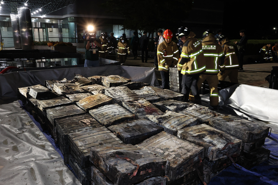 Firefighters submerge lithium-ion batteries in water while extinguishing a fire at the National Information Resources Service in Daejeon, some 160 kilometers southeast of Seoul, on Sept. 27. [YONHAP]