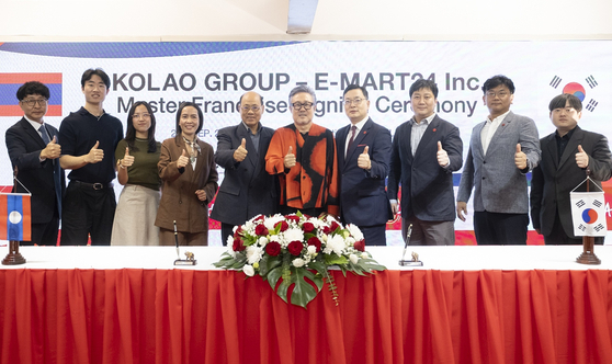 Officials from Emart24 and Kolao pose for photos after signing an agreement on a master franchise deal to open the Korean convenience store franchise in Laos on Sept. 25. [EMART24]