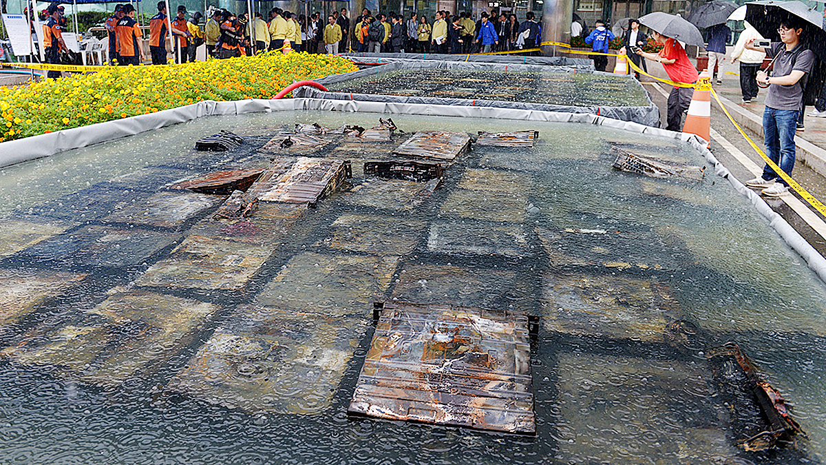 Lawmakers on the National Assembly’s Public Administration and Security Committee and related officials inspect lithium-ion batteries retrieved from the fire site at the National Information Resources Service in Daejeon on Sept. 28. [KIM SUNG-TAE]