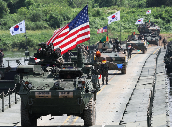 A U.S. Stryker armored vehicle and a Korean K200 armored vehicle cross a floating bridge during a joint river-crossing exercise in Yeoju, Gyeonggi, on Aug. 27. [YONHAP]
