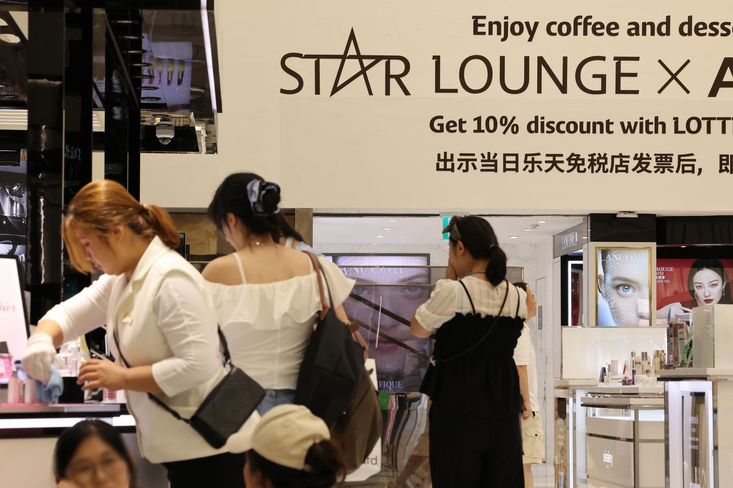Tourists shop at a Lotte Duty Free store in Jung District, central Seoul on Sept. 7. [YONHAP]