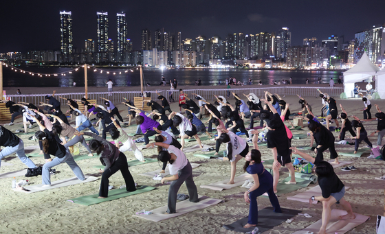 Citizens take part in a night workout class in Busan on Sept. 14. [YONHAP]