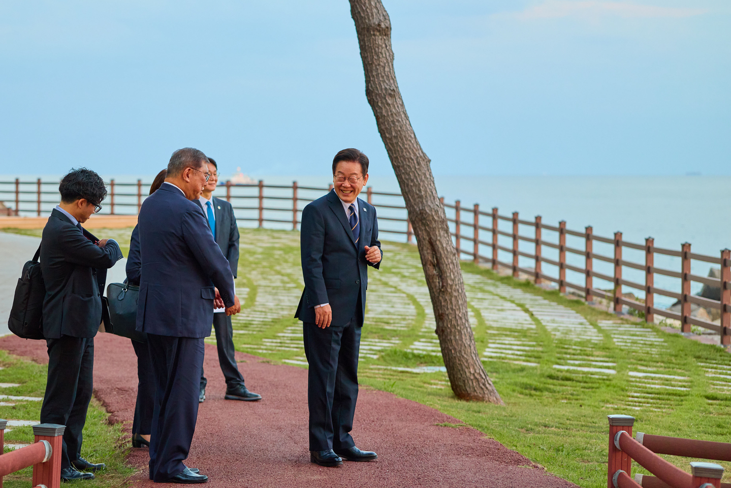 President Lee Jae Myung, right, and Japanese Prime Minister Shigeru Ishiba, center, take a walk around the Nurimaru APEC House in Busan on Sept. 30 after their bilateral summit. [PRESIDENTIAL OFFICE]