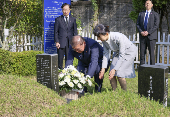 Japanese Prime Minister Shigeru Ishiba and first lady Yoshiko Ishiba pay respects to Lee Soo-hyun, a Korean student who lost his life trying to save a Japanese man at a subway station in Tokyo in 2001, at a cemetery in Busan ahead of a summit with President Lee Jae Myung on Sept. 30. [YONHAP]
