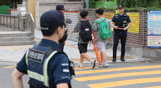 Police patrol around an elementary school in Daegu amid an increase in attempted kidnapping cases across the country on Sept. 12. [YONHAP]