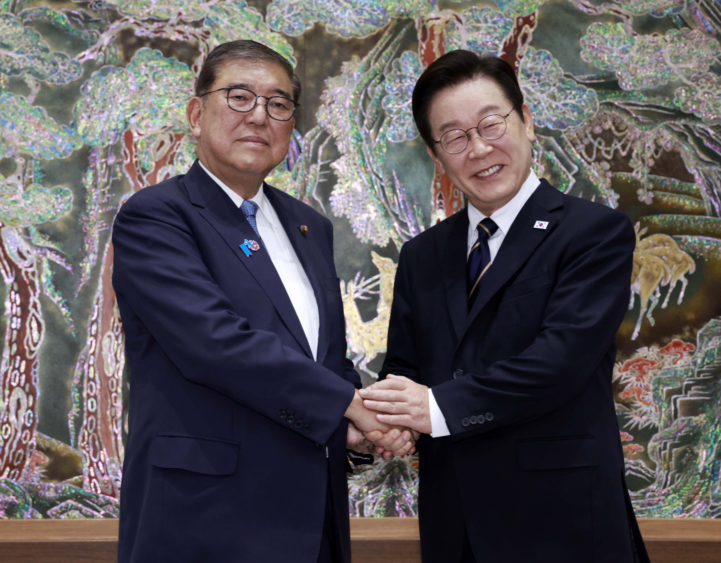 President Lee Jae Myung, right, and Japanese Prime Minister Shigeru Ishiba shake hands ahead of their bilateral summit at Nurimaru APEC House in Busan on Sept. 30. [JOINT PRESS CORPS]