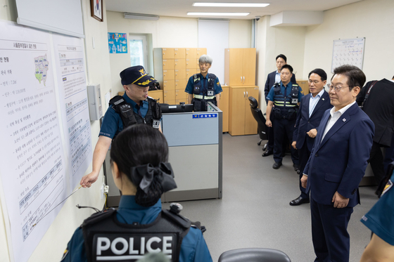 President Lee, right, is briefed about public security and safety efforts by police officers at the Yaksu Police Station in central Seoul on Oct. 3. [PRESIDENTIAL OFFICE]