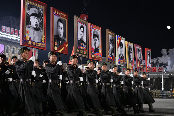 Soidiers carry portraits of anti-Japanese partisans and figures credited with advancing the military during a nighttime parade at Kim Il Sung Square in Pyongyang on Feb. 8, 2023, marking the 75th anniversary of the founding of the Korean People’s Army. [RODONG SINMUN]