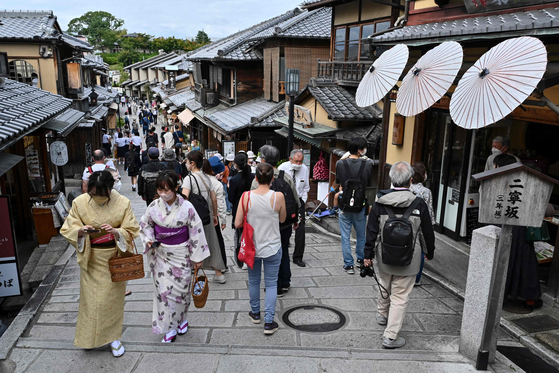  People walk along one of the lanes filled with touristy shops and restaurants leading to Kiyomizu-dera temple in Kyoto on Oct. 13, 2022. [AFP/YONHAP]