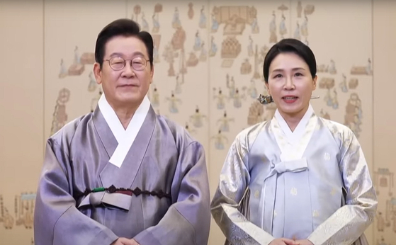 President Lee Jae Myung, left, and first lady Kim Hea Kyung offer Chuseok holiday greetings in a video released on Oct. 4. [YONHAP] 