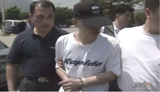 Lee Eun-seok, who murdered his parents, is escorted by police in this undated screen capture. [SCREEN CAPTURE]
