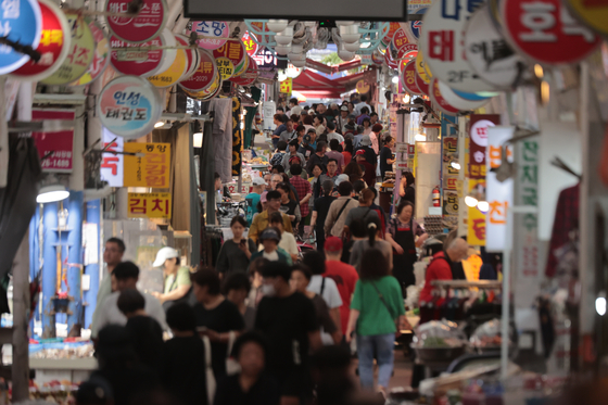 Visitors look at items at a traditional market in Seoul on Oct. 2. [YONHAP] 