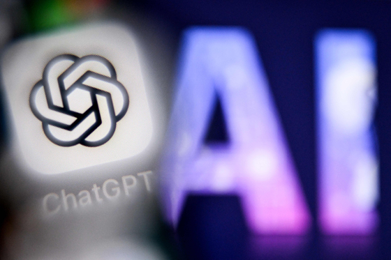 A photo taken on Sept. 1 shows the letters AI for Artificial Intelligence on a laptop screen, right, next to the logo of the ChatGPT application on a smartphone screen in Frankfurt am Main, western Germany. [AFP/YONHAP]