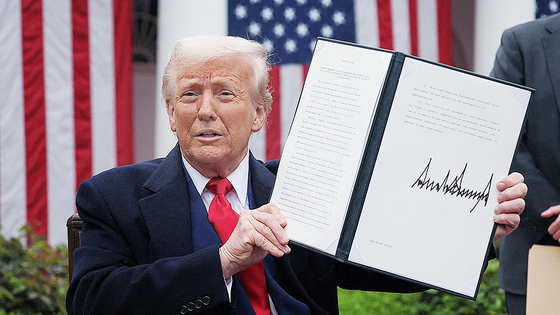 U.S. President Donald Trump holds a signed executive order on tariffs, in the Rose Garden at the White House in Washington on April 2. [REUTERS/YONHAP]