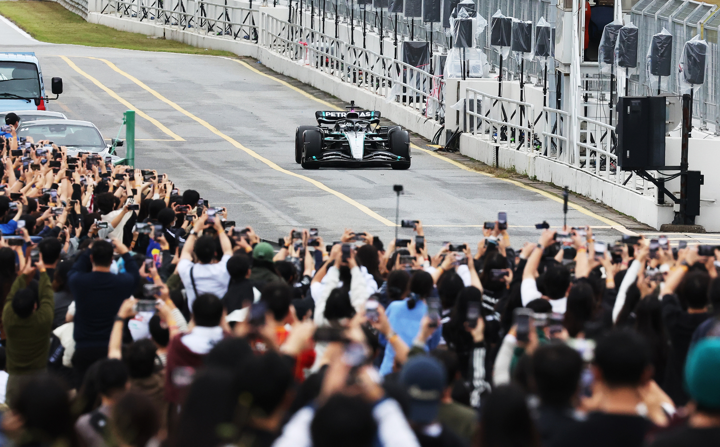   Spectators raise their smartphones to snap photos of a Mercedes-AMG Petronas Formula One car driven by Valtteri Bottas as it speeds around the track during the Peaches Run Universe 2025 event at Everland Speedway in Yongin, Gyeonggi, on Oct. 12. [YONHAP]