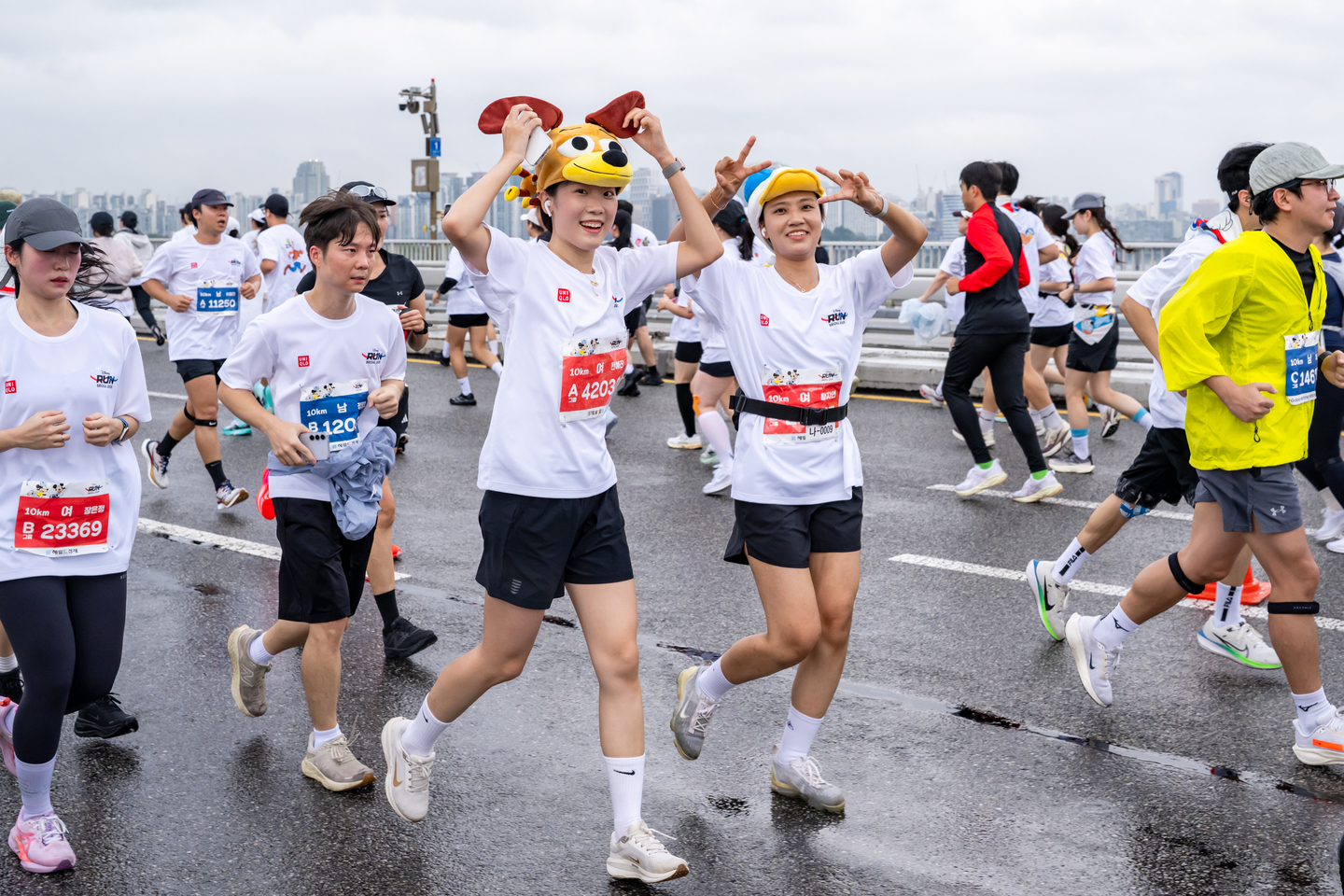 Ten-kilometer course runners wearing Disney hats at the inaugural Disney Run Seoul 2025 pose for a photo while crossing the Seogang Bridge on Oct. 11. [WALT DISNEY COMPANY KOREA]