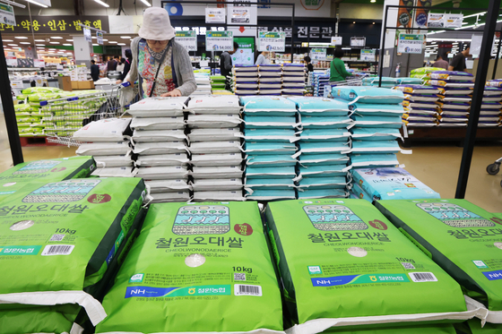 Shoppers examine bags of rice at a large supermarket in Seoul on Oct. 12 as rice prices continue to surge. [NEWS1] 