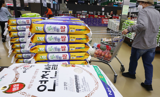 Shoppers examine bags of rice at a large supermarket in Seoul on Oct. 12 as rice prices continue to surge. [NEWS1] 
