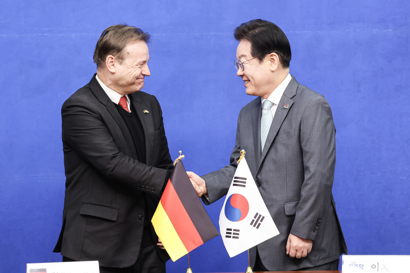 Then-liberal Democratic Party chief Lee Jae Myung shakes hands with German Ambassador to Korea Georg Schmidt at the National Assembly in western Seoul on Feb. 6. [KIM KYOUNG-ROK]