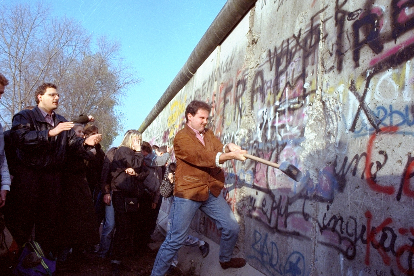 An unidentified West Berliner swings a sledgehammer, trying to destroy the Berlin Wall near Potsdamer Platz in Berlin on Nov. 12 in 1989. [AP/YONHAP]