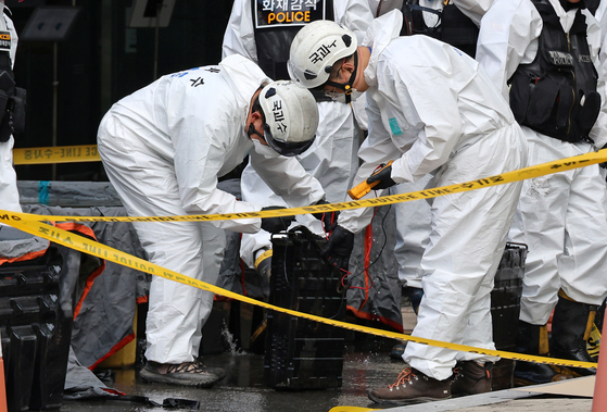 Police officers inspect lithium-ion batteries used for uninterruptible power supply systems at the site of a fire at the National Information Resources Service in Yuseong District, Daejeon, on Sept. 29. The blaze, which broke out on Sept. 26, crippled a wide range of government digital services. [YONHAP]