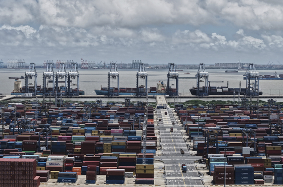 Trucks loaded with container move through a container terminal port in Shanghai, China, Aug. 7. [AP/YONHAP]