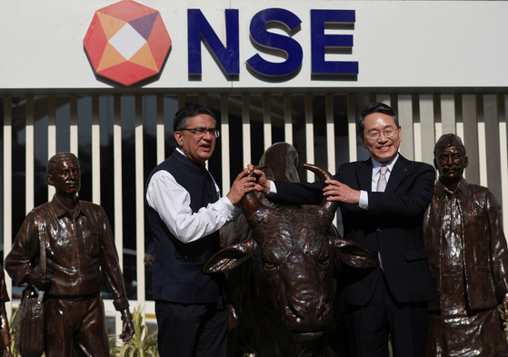 Managing Director and CEO of National Stock Exchange (NSE) Ashish Chauhan, left, and CEO of LG Electronics William Cho pose with the statue of the NSE bull, ahead of the listing ceremony of LG Electronics India Limited's Initial Public Offering at NSE, in Mumbai, India on Oct. 14. [REUTERS/YONHAP]