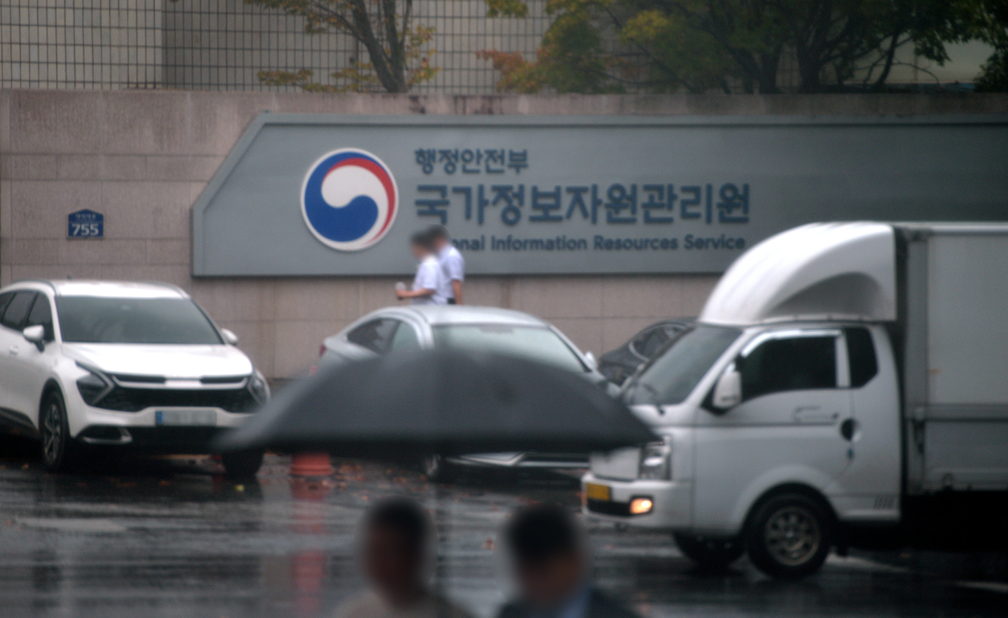 Officials walk through the main gate of the National Information Resources Service headquarters in Daejeon on Oct. 13. [JOONGANG ILBO] 