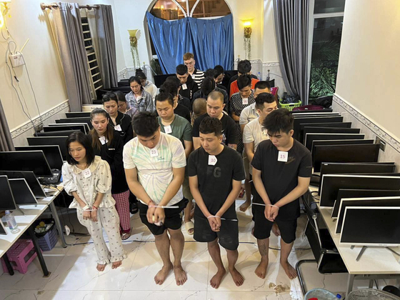 In this photo released by Agence Kampuchea Press, online scammers arrested by authorities stand in a building in Sihanoukville province, southwestern of Phnom Penh, Cambodia on July 15. [AP/YONHAP]