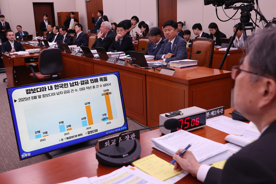 Foreign Minister Cho Hyun, right, listens to a lawmaker's question about crimes targeting Koreans in Cambodia during an audit by the parliamentary Foreign Affairs Committee at the National Assembly in Seoul on Oct. 13. [YONHAP]
