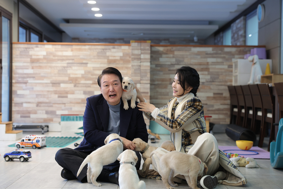 Former President Yoon Suk Yeol, left, is seen with his wife Kim Keon Hee and their pet dogs in 2023. [PRESIDENTIAL OFFICE]