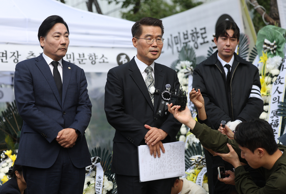 Lawyer Park Kyung-ho, center, speaks during a news conference at a memorial altar for a Yangpyeong County official in downtown Seoul on Oct. 14. [YONHAP]