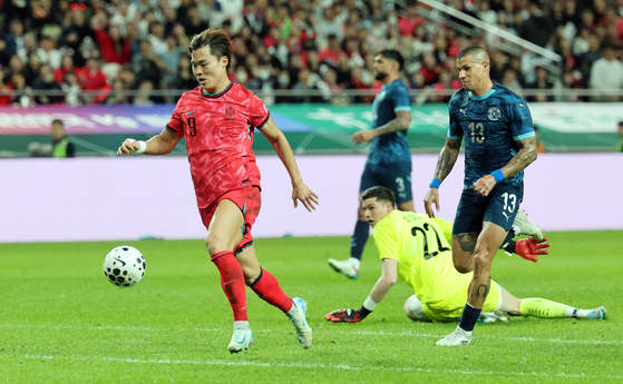 Oh Hyeon-gyu of Korea, left, moves past Paraguay goalkeeper Orlando Gill for a goal during the teams' friendly football match at Seoul World Cup Stadium in Seoul on Oct. 14. [YONHAP]