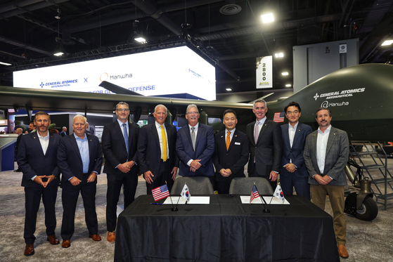 This photo, taken Oct. 14 and provided by Hanwha Aerospace Co., shows officials from the Korean defense company and U.S.-based General Atomics Aeronautical Systems Inc. (GA-ASI) posing for a photo after signing an agreement to jointly develop a short take-off and landing (STOL) unmanned aerial vehicle (UAV) during the Association of the United States Army (AUSA) defense exhibition in Washington. [YONHAP]