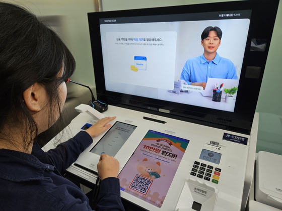 An AI assistant serves a customer at Shinhan Bank’s AI-powered branch in central Seoul. [SHINHAN BANK]