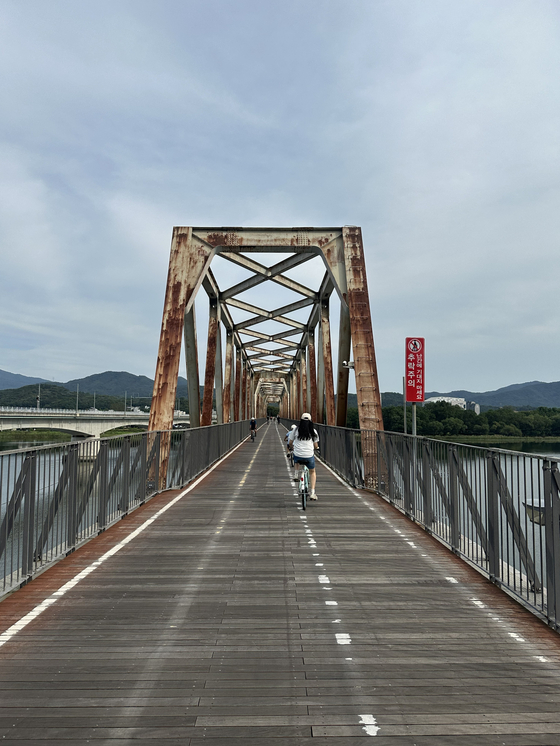 The Bukhangang Railroad Bridge spans the mouth of the Bukhan River on Sept. 27. A former railway bridge converted for cyclists, the bridge is one of the early highlights of the cross-country route.  [JIM BULLEY]