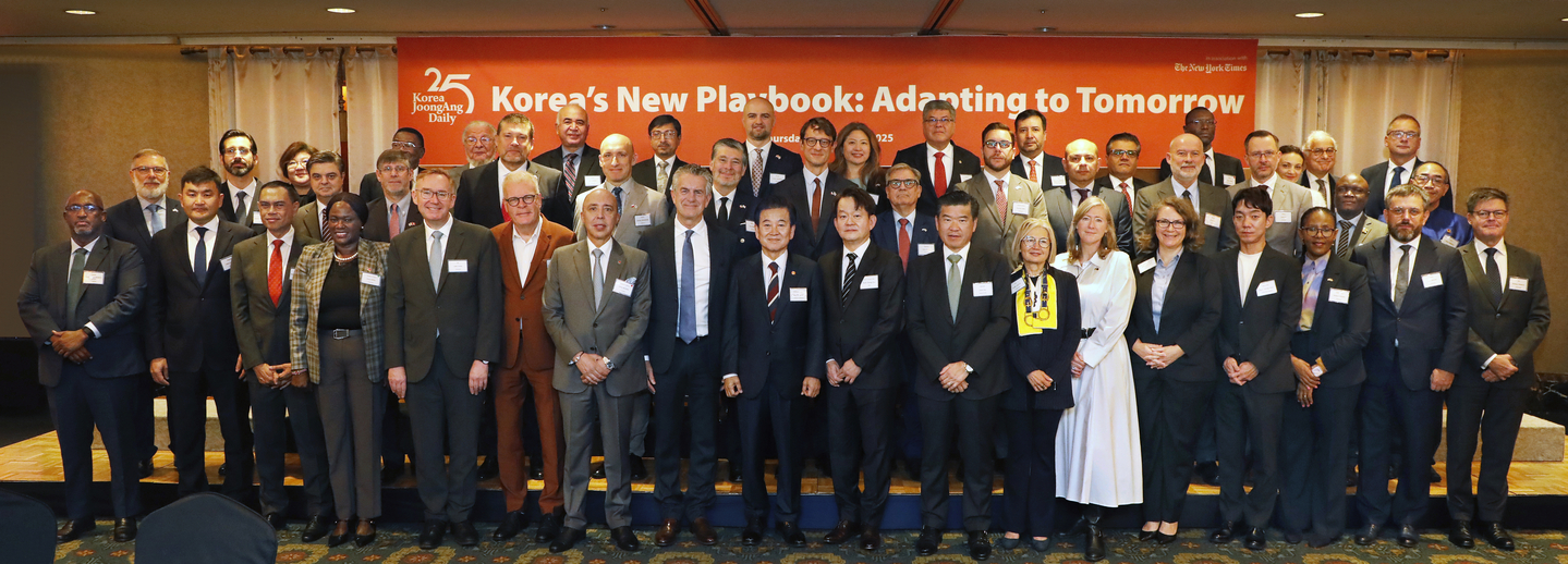 Stephen Dunbar-Johnson, president, international of The New York Times, eighth from left, front row; Chung Dong-young, minister of unification, ninth from left; Park Chang-hee, CEO of the JoongAng Ilbo and Korea JoongAng Daily, tenth from left; James Kim, chairman and CEO of Amcham Korea, eleventh from left; and Park Jeong-moo, senior vice president of Nexon Korea, fourth from right, pose for a group photo with ambassadors and chargés d’affaires during the opening of the 2025 Korea JoongAng Daily Forum at the Lotte Hotel in Jung District, central Seoul, on Oct. 16. [PARK SANG-MOON]