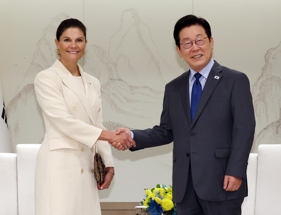 President Lee Jae Myung, right, shakes hands with Swedish Crown Princess Victoria during their meeting at the presidential office in central Seoul on Oct. 15. [YONHAP]