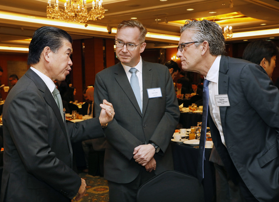 Amcham CEO and Chairman James Kim, left, speaks to British Ambassador Colin Crooks, center, and Stephen Dunbar-Johnson, president, international of The New York Times. [PARK SANG-MOON]