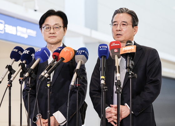 Kim Yong-beom, right, the presidential chief of staff for policy, and Industry Minister Kim Jung-kwan, left, field questions from reporters at Incheon International Airport, which is west of Seoul, on Oct. 16 before their departure to Washington for trade talks with the United States. [KIM KYUNG-ROK]